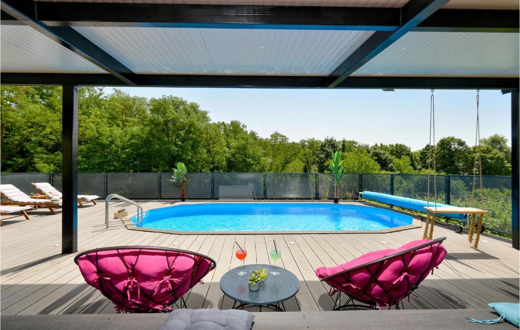 a patio with a pool and two pink chairs at Gorgeous Home In Graberje Ivanicko With Wifi in Graberje Ivanićko