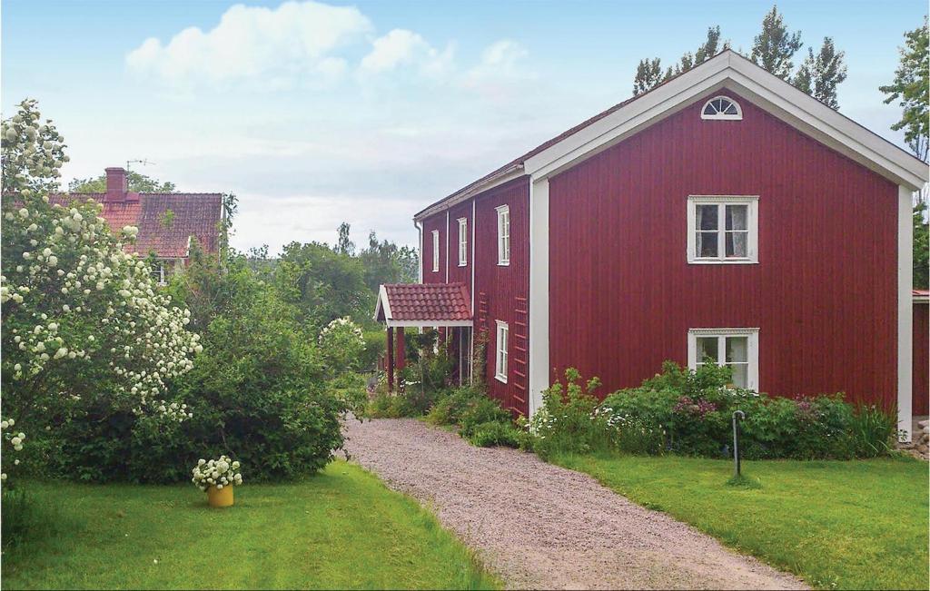 un granero rojo con un camino de grava al lado en Amazing Home In Vimmerby With House Sea View, en Vimmerby