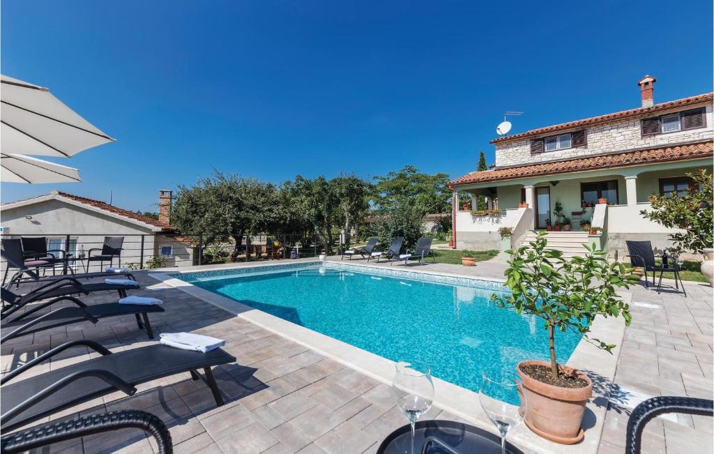 basen z krzesłami i dom w obiekcie Cozy Apartment In Pilkovici With Wifi w mieście Pajkovići