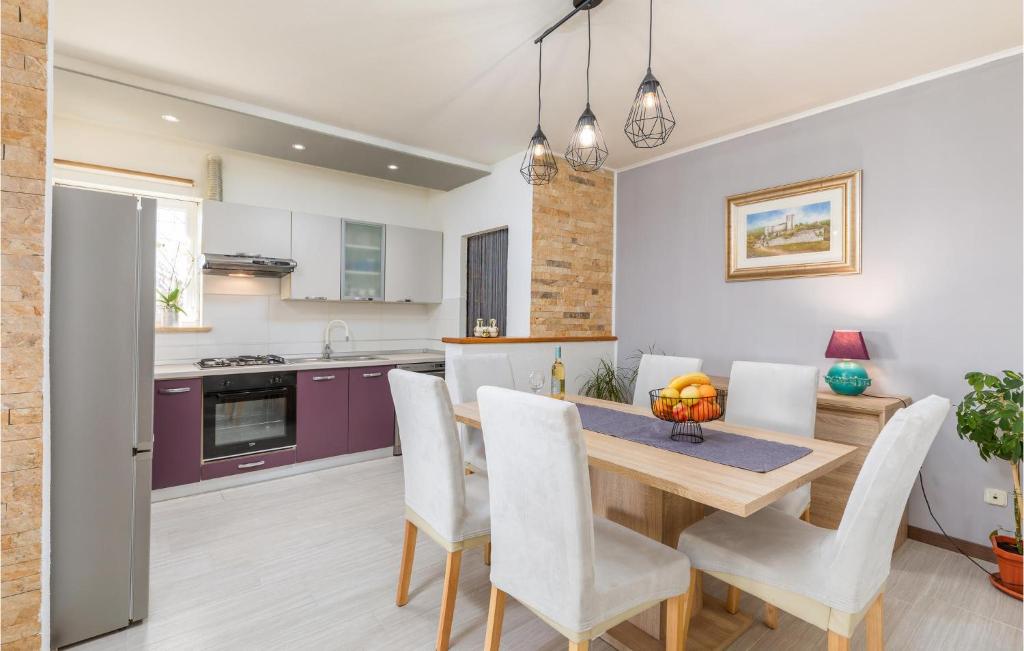 kuchnia i jadalnia z drewnianym stołem i krzesłami w obiekcie Cozy Apartment In Pilkovici With Wifi w mieście Pajkovići
