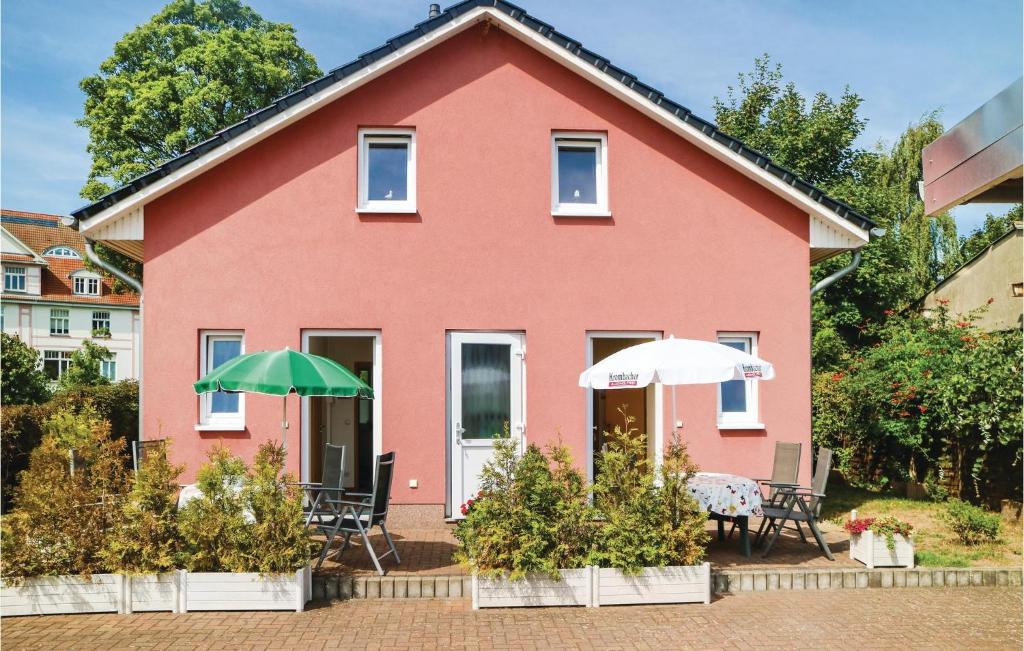 a red house with two umbrellas in front of it at 1 Bedroom Stunning Apartment In Khlungsborn in Kühlungsborn