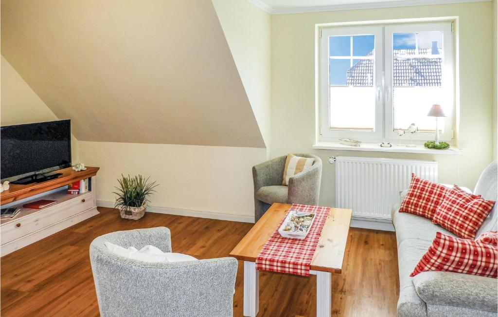 a living room with a tv and a table and chairs at 2 Bedroom Cozy Apartment In Dagebüll in Dagebüll