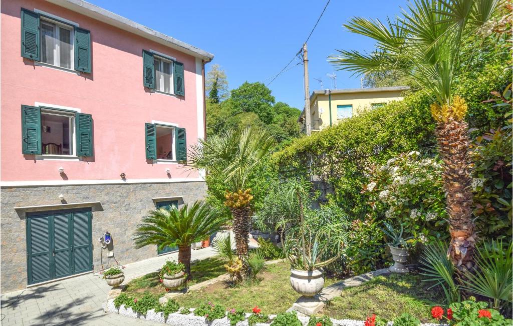 una casa rosa con palmeras delante en 3 Bedroom Amazing Apartment In Genova en Génova