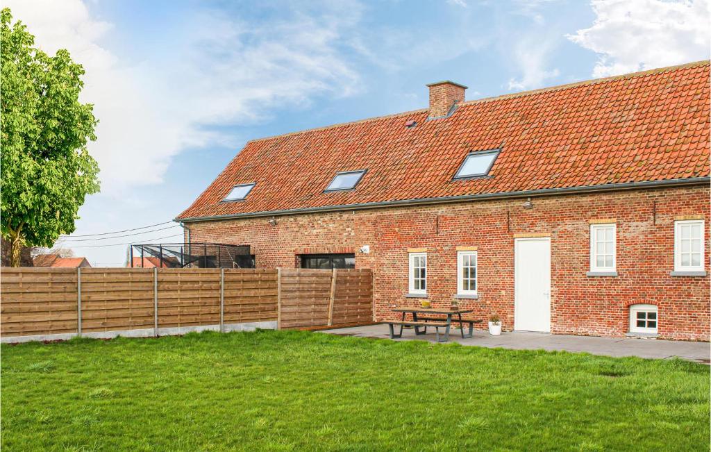a brick house with a wooden fence and a picnic table at Amazing Home In Stavele With 4 Bedrooms And Wifi in Stavele