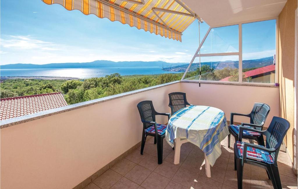 a balcony with a table and chairs and a view of the water at Beautiful Apartment In Smrika With Wifi in Šmrika