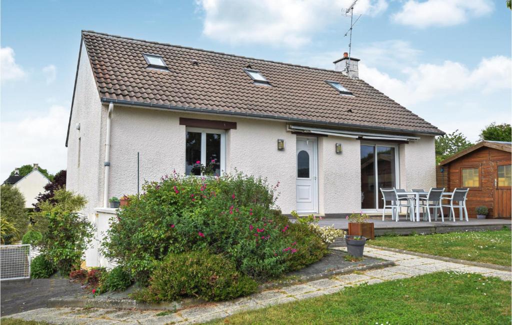 une maison blanche avec une table et des chaises dans une cour dans l'établissement Lovely Home In Marcey-les-grves With Kitchen, à Marcey-les-Grèves