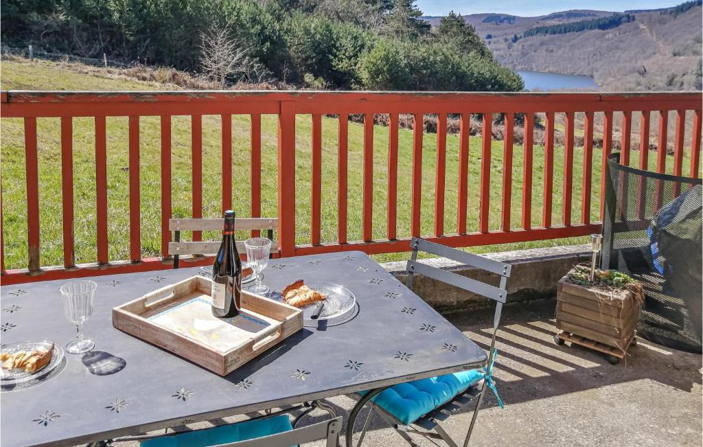 einen Picknicktisch mit einer Flasche Wein auf dem Deck in der Unterkunft Stunning Home In La Salvetat-sur-agout With Wifi in La Salvetat