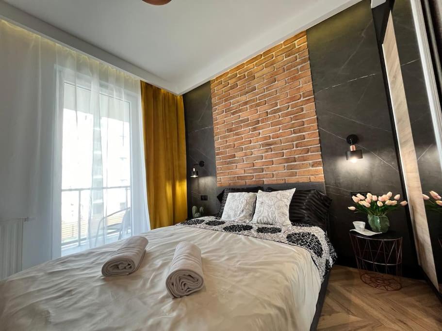 um quarto com uma cama grande e uma parede de tijolos em Turzycowa Loft - stylish apartment em Gdansk