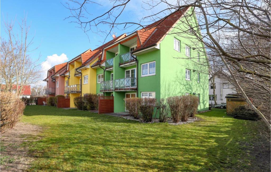 une rangée de maisons vertes et jaunes dans l'établissement Fewo Neuschnberg Eg, à Neu Schönberg
