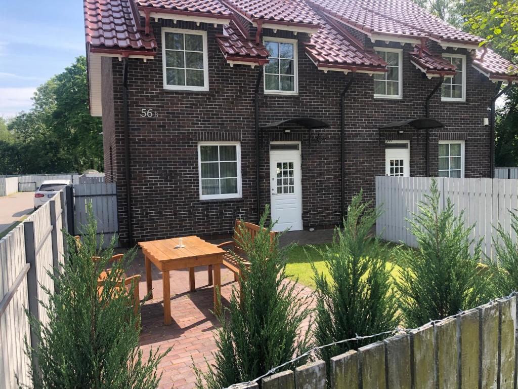 a house with a wooden table in front of it at Karkle Seaside Apartments in Karklė