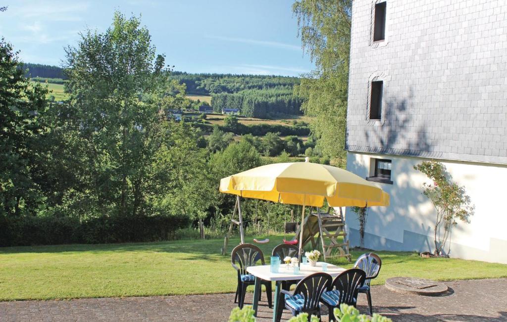 a table and chairs under a yellow umbrella at 4 Bedroom Awesome Home In Schnberg in Schoenberg