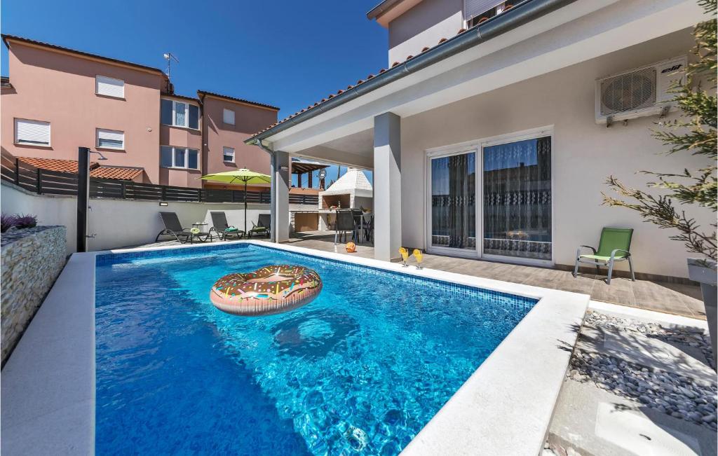 a swimming pool in the backyard of a house at Beautiful Home In Skatari With Outdoor Swimming Pool in Škatari