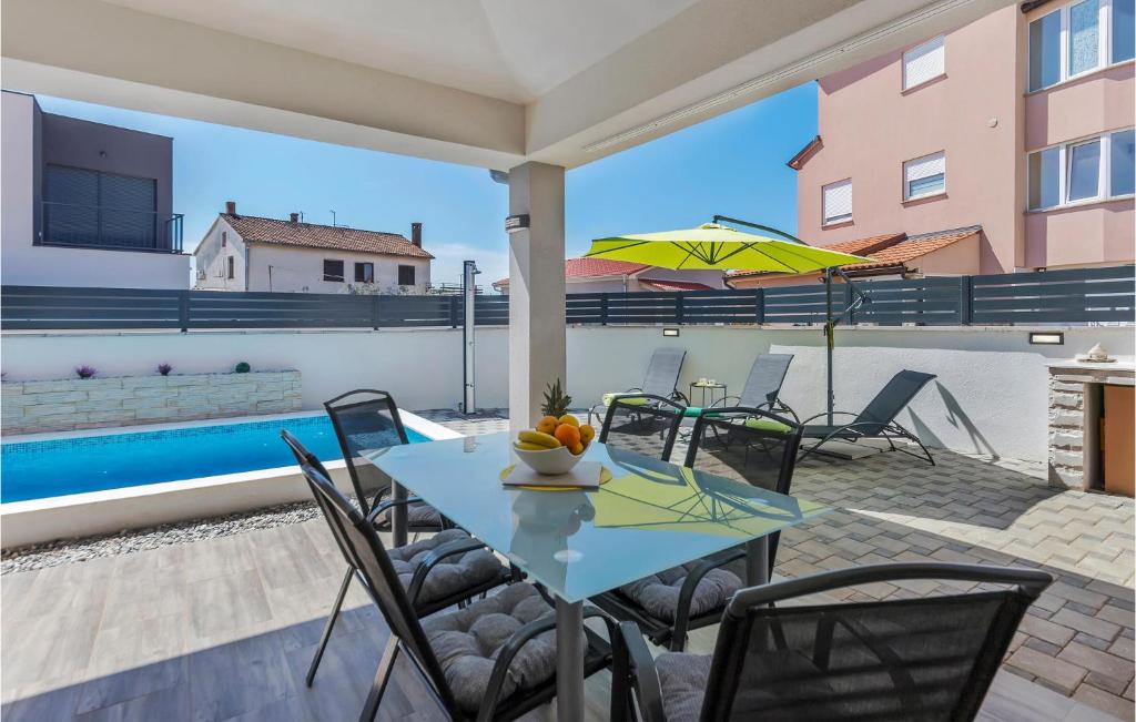 a patio with a table and chairs and a pool at Beautiful Home In Skatari With Outdoor Swimming Pool in Škatari