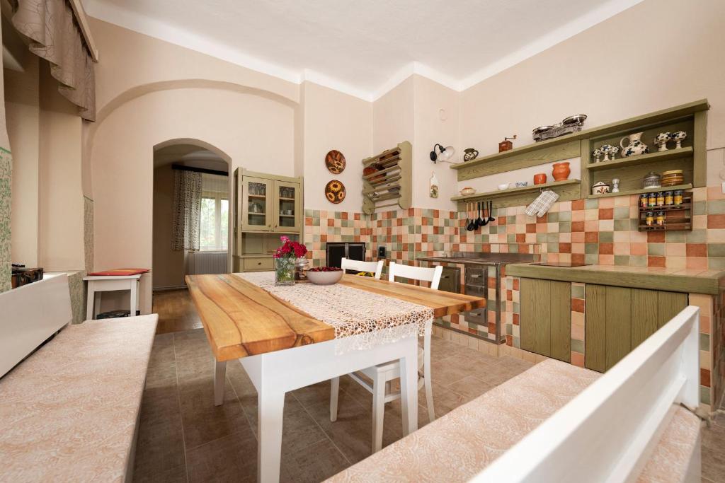 ein Esszimmer mit einem Tisch und einer Küche in der Unterkunft Apartment Island Country House in Savinja Valley in Žalec