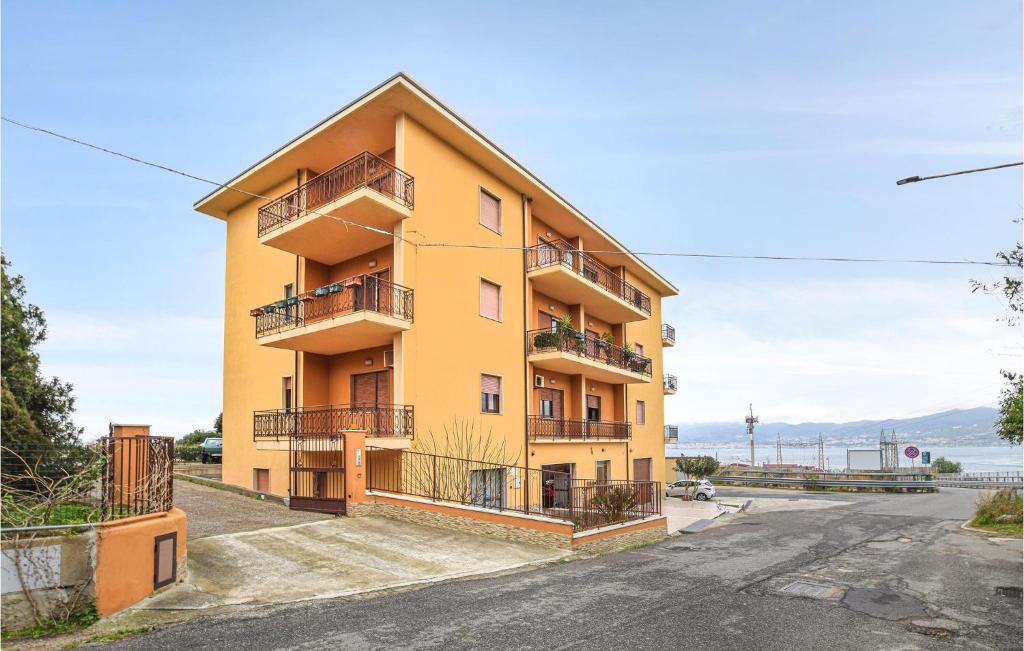 um edifício amarelo com varandas numa rua em Lovely Apartment In Campo Calabro With House Sea View em Campo Calabro