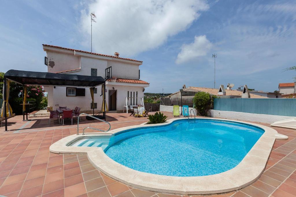 uma piscina em frente a uma casa em Villa Lilia em Vilanova i la Geltrú