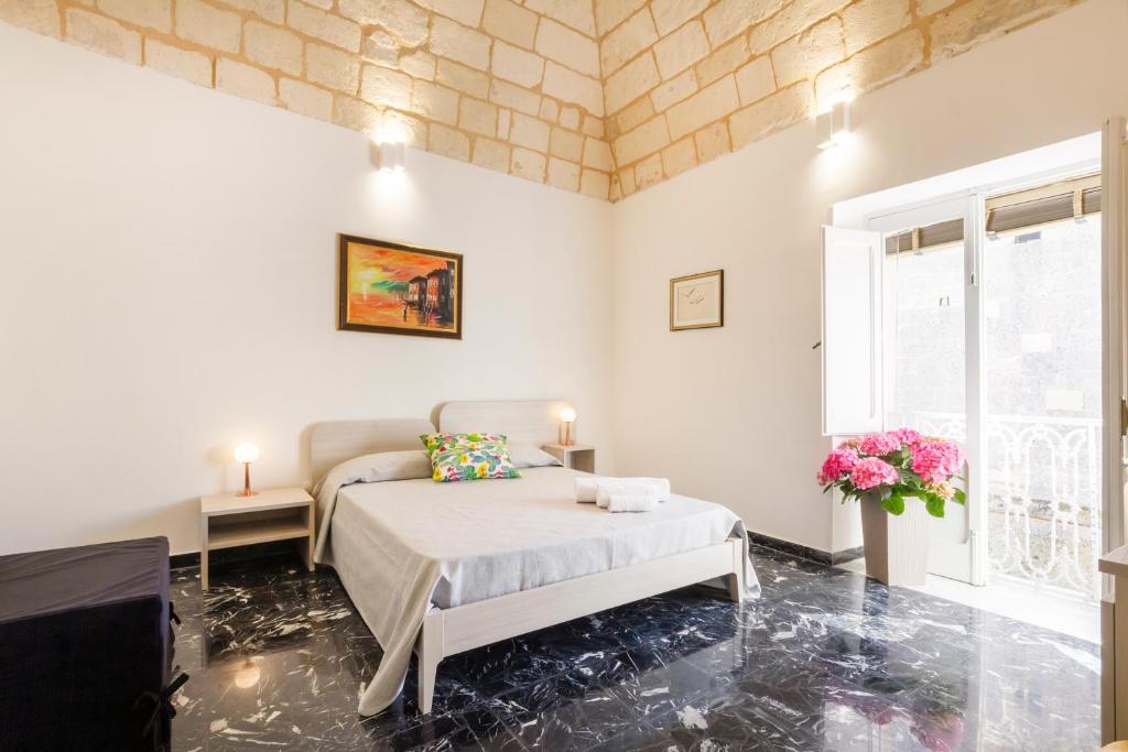 a bedroom with a bed and a couch and a window at Civico 22 B&B in Cannole