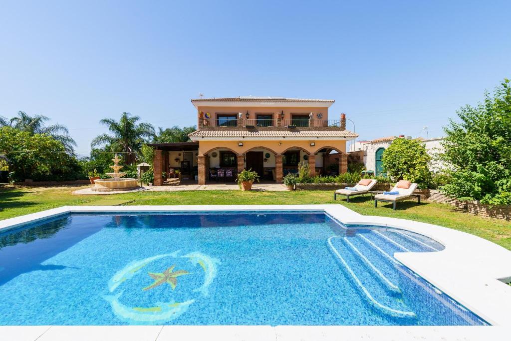 a house with a swimming pool in front of a house at La Huerta Del Sur in Alhaurín el Grande
