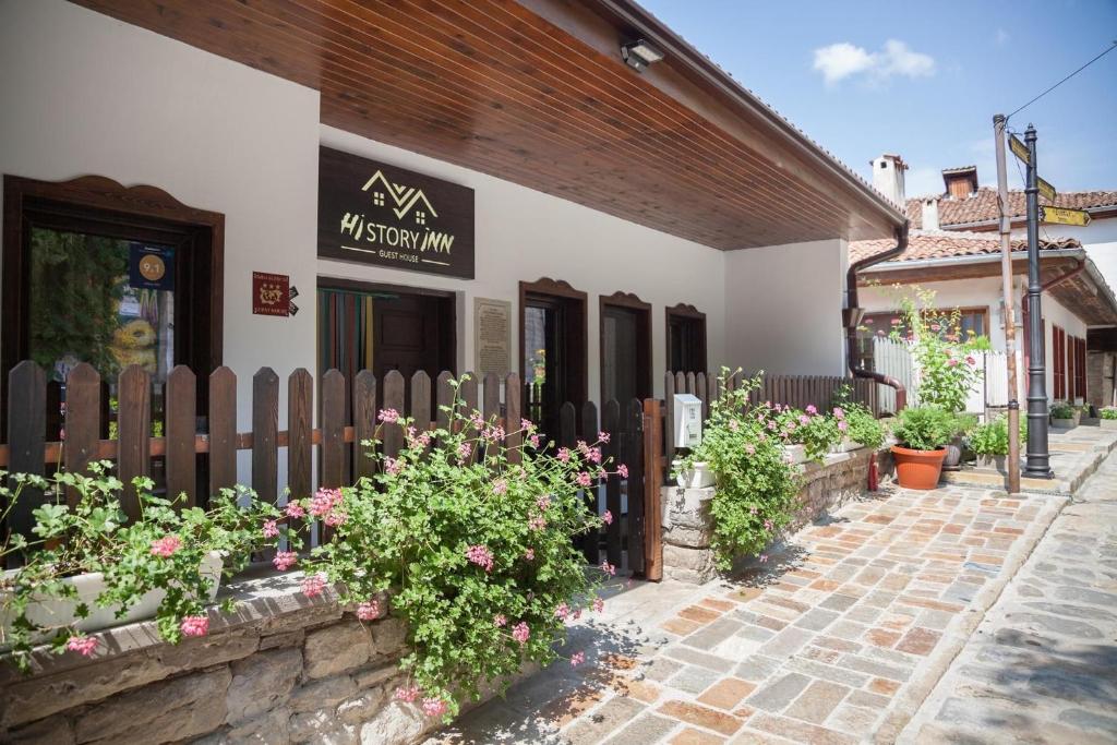 a building with a fence and flowers in front of it at HiStory INN Unique Guest House in Veliko Tŭrnovo