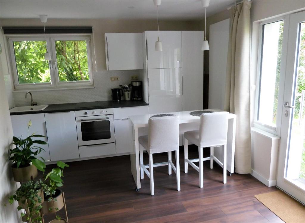 a kitchen with white cabinets and a table and chairs at Apartment Ankenbrand in Randersacker