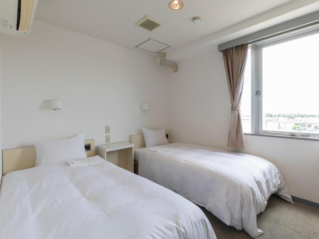 Postel nebo postele na pokoji v ubytování Tabist Hotel Yuan Akashi