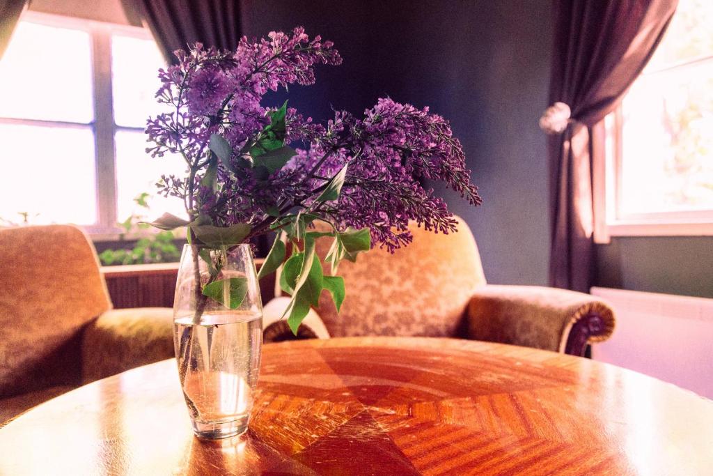 a vase of purple flowers sitting on a table at Palazzo Patriarcale in Turku in Turku