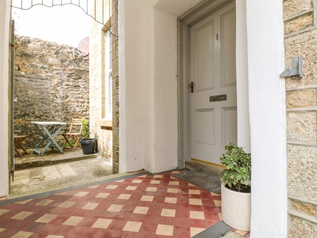 a hallway with a door and a checkered floor at 1 Regents Mews in Penzance