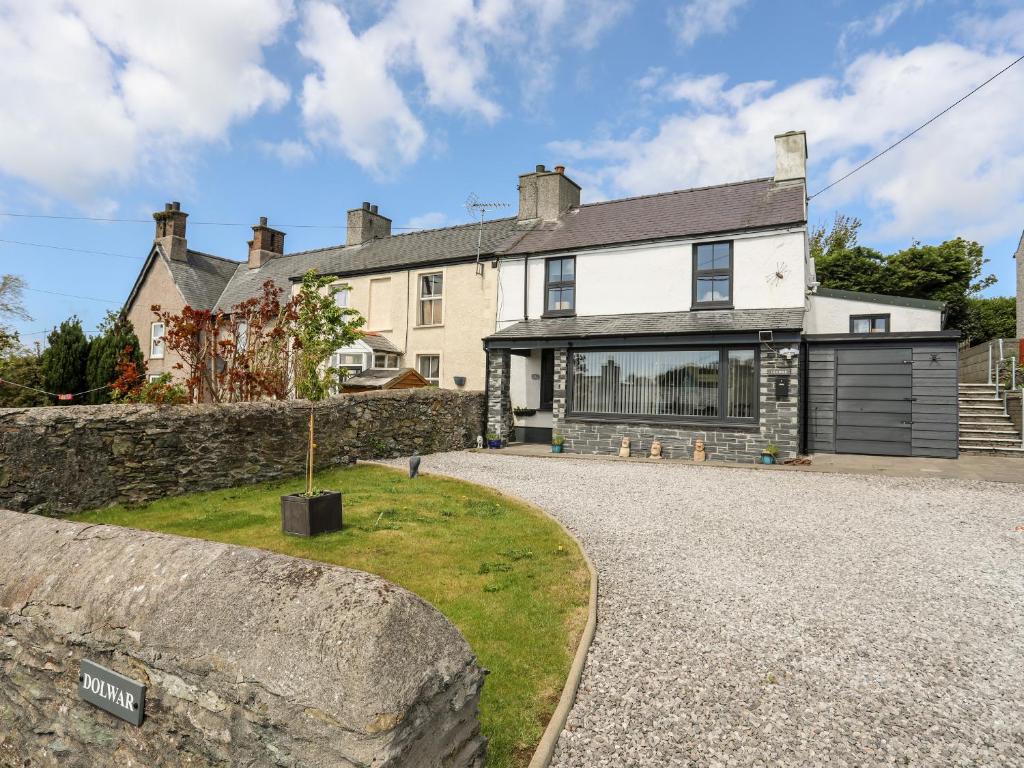 a large white house with a stone wall at Dolwar in Amlwch