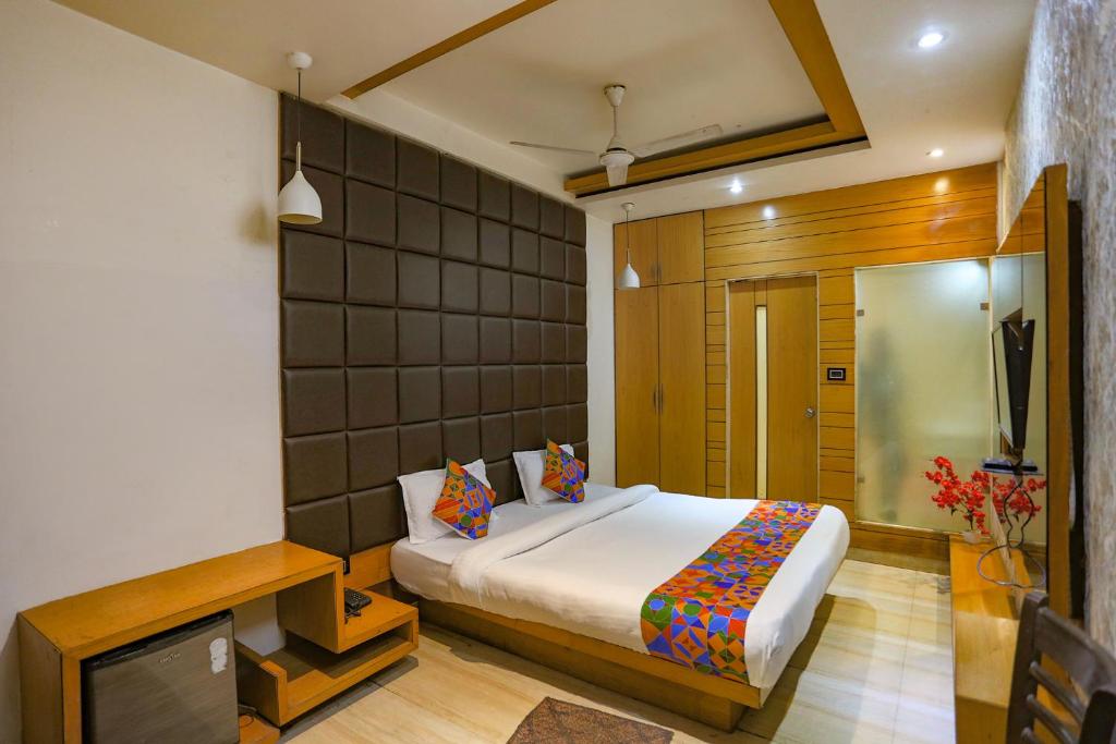 1 dormitorio con 1 cama y TV. en FabHotel Sun Park en Bhopal