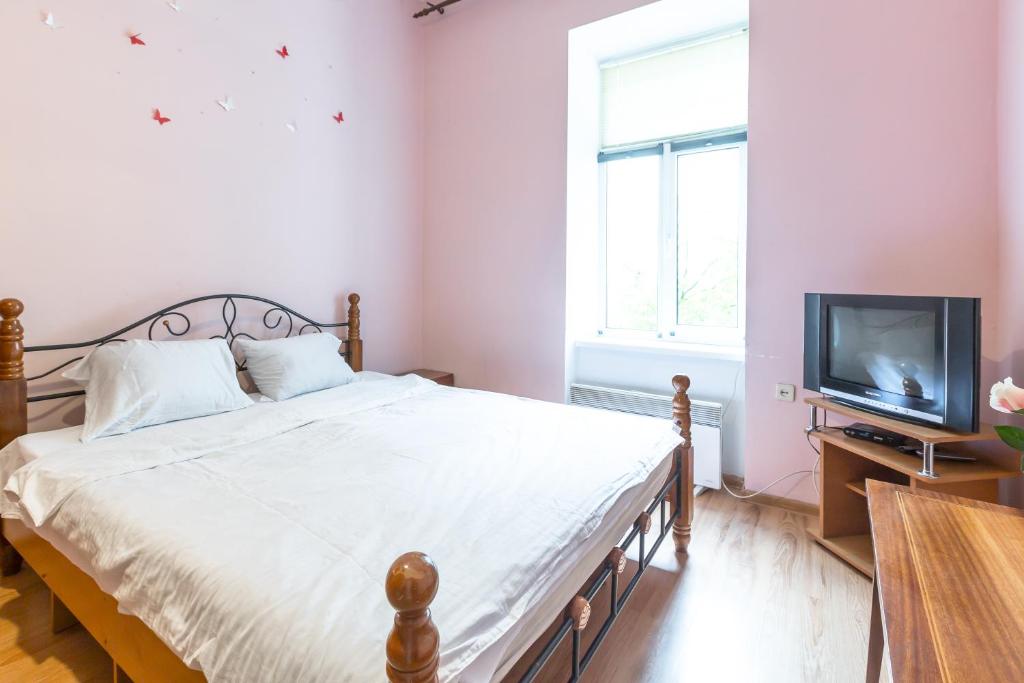 a bedroom with a bed and a television at Квартира на вулиці Федорова 29 біля Площі Ринок Підвальна in Lviv