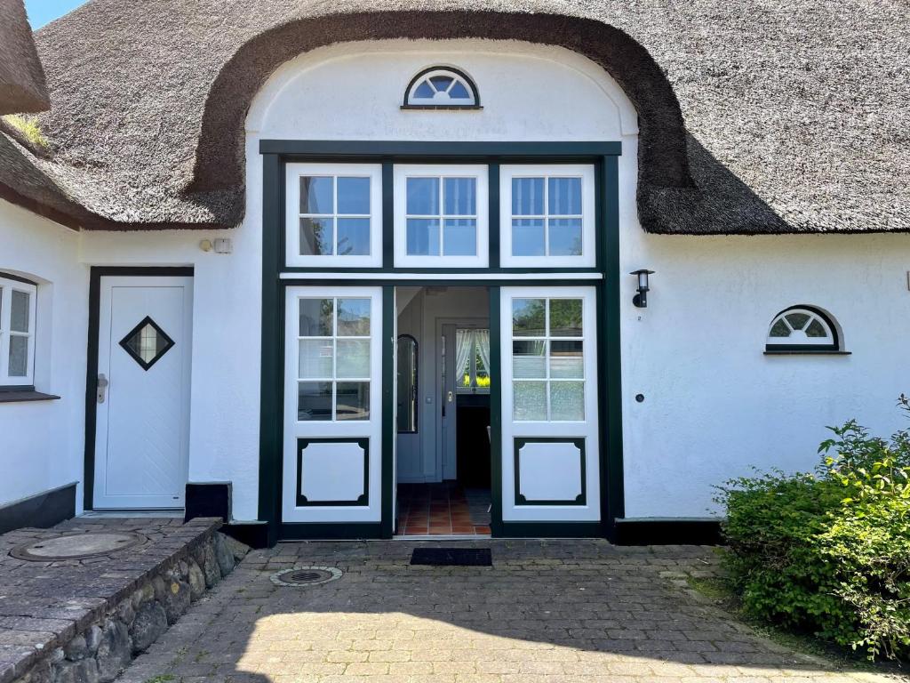 a white house with a thatched roof at Landhaus Tons 2 Jan in Keitum