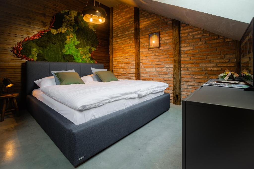 a bedroom with a large bed in a brick wall at Blue Bell Penzión in Košice