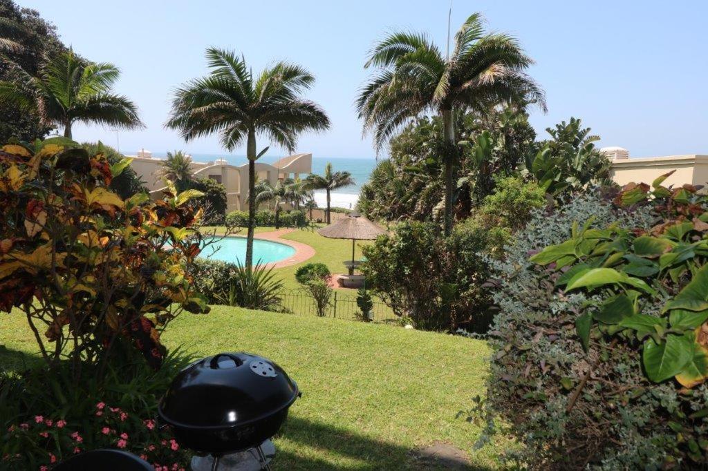a view of a resort with a swimming pool and palm trees at Mallorca 13 Duplex in Umdloti