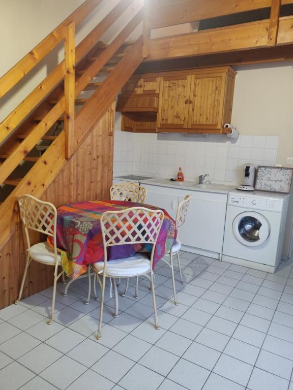 una cucina con tavolo, sedie e lavatrice di Maison au Coeur des Sables d'Olonne a Les Sables-dʼOlonne