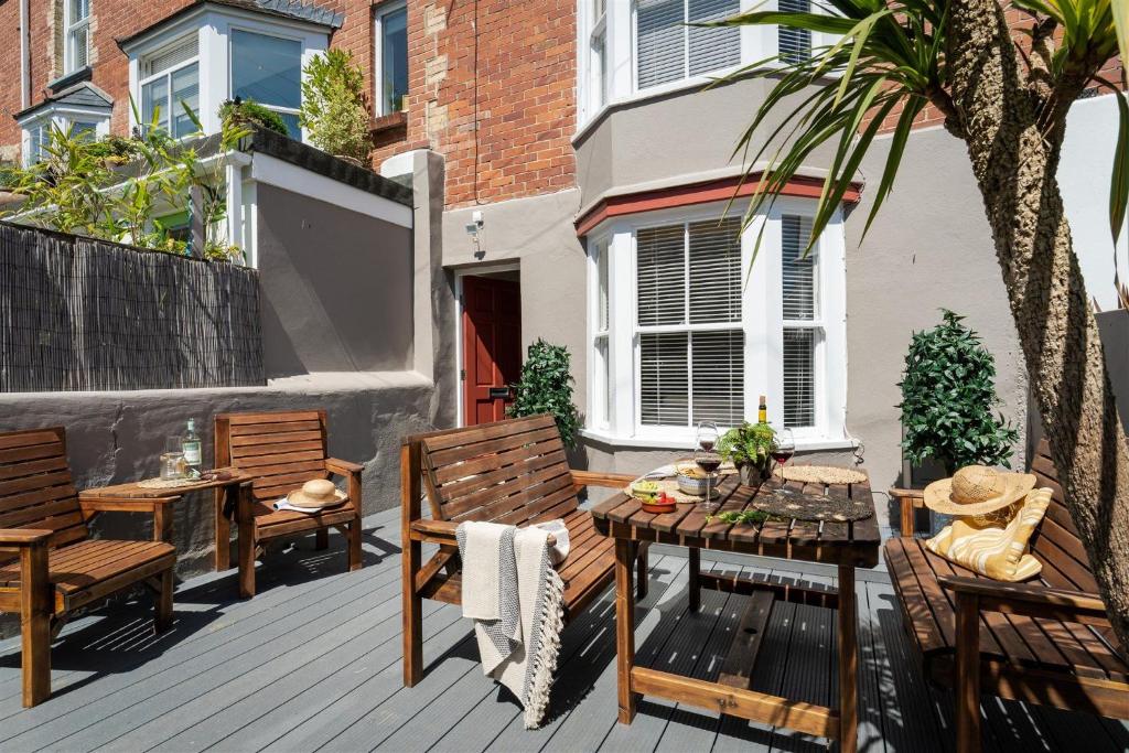een patio met 2 stoelen, een tafel en een boom bij Gulls Rest - Charming Cottage in the heart of historic Dartmouth in Dartmouth