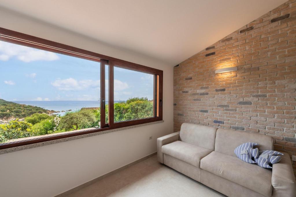 a living room with a couch and a large window at Casa vacanza Porto Luna Villasimius in Villasimius