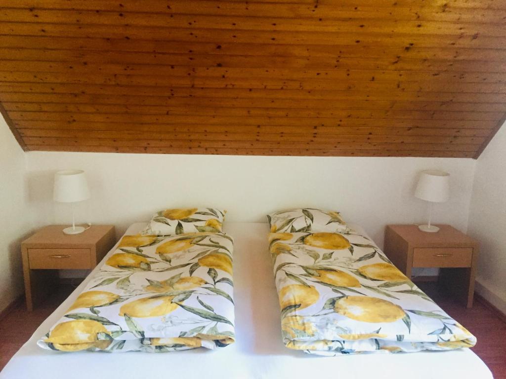 a bedroom with two beds and two night stands at Summerside Apartman Harkány in Harkány