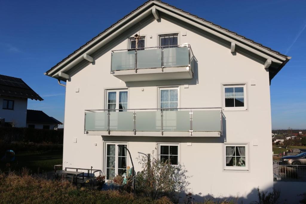 een wit huis met een balkon bij Ferienwohnungen Christoph in Pfaffing