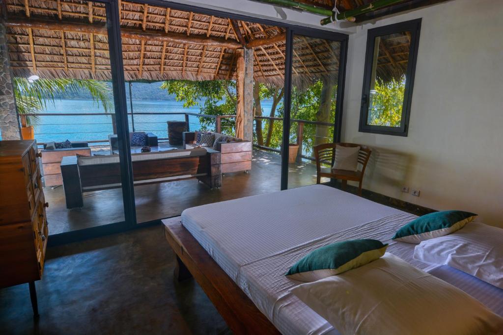a bedroom with two beds and a view of the ocean at Villa Nautilus in Nosy Komba