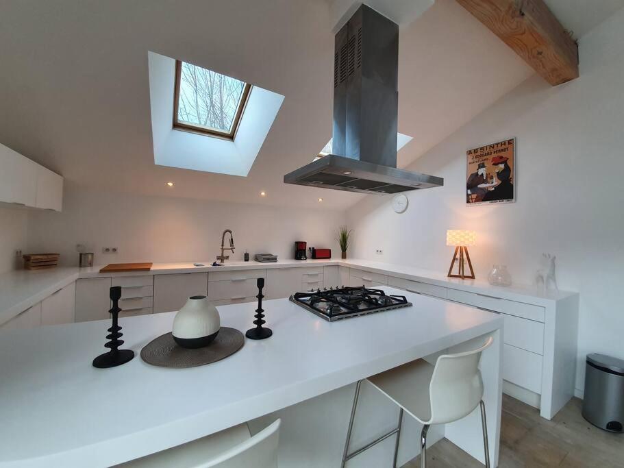 a white kitchen with a stove and a sink at Chalet entier 110m2 avec vue et sauna à 10 min des pistes in Sainte-Foy-Tarentaise