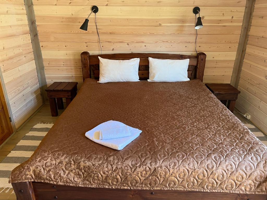 Cama en habitación de madera con 2 almohadas y colchón en Hotel Repvåg, en Repvåg