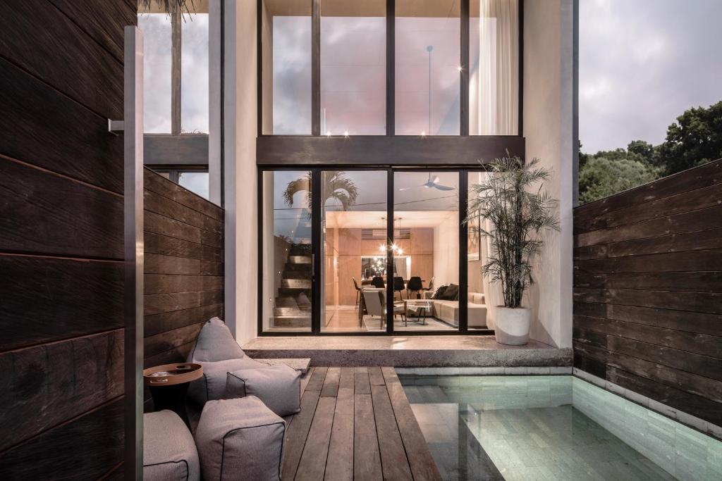 a house with a swimming pool in front of a window at OXO Townhouses Berawa Canggu in Canggu