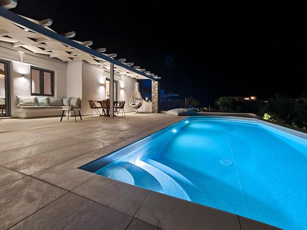 a swimming pool in front of a house at night at Isalos Villas with private pool, sleeps 4 in Naxos Chora