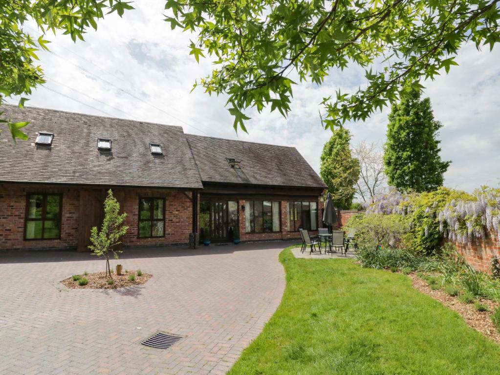 an exterior view of a brick house with a patio at The Stables in Stourbridge