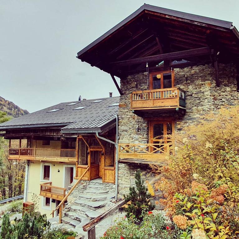 une maison avec un balcon sur le côté dans l'établissement Appartement Gentiane de 85m2 avec sauna à 10 min des pistes, à Sainte-Foy-Tarentaise
