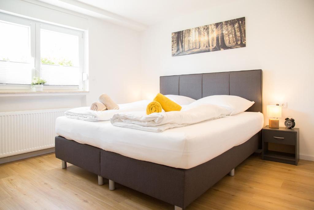 ein Schlafzimmer mit einem großen Bett mit weißer Bettwäsche in der Unterkunft Ferienwohnung Am Kahlenberg - Ringsheim in Ringsheim