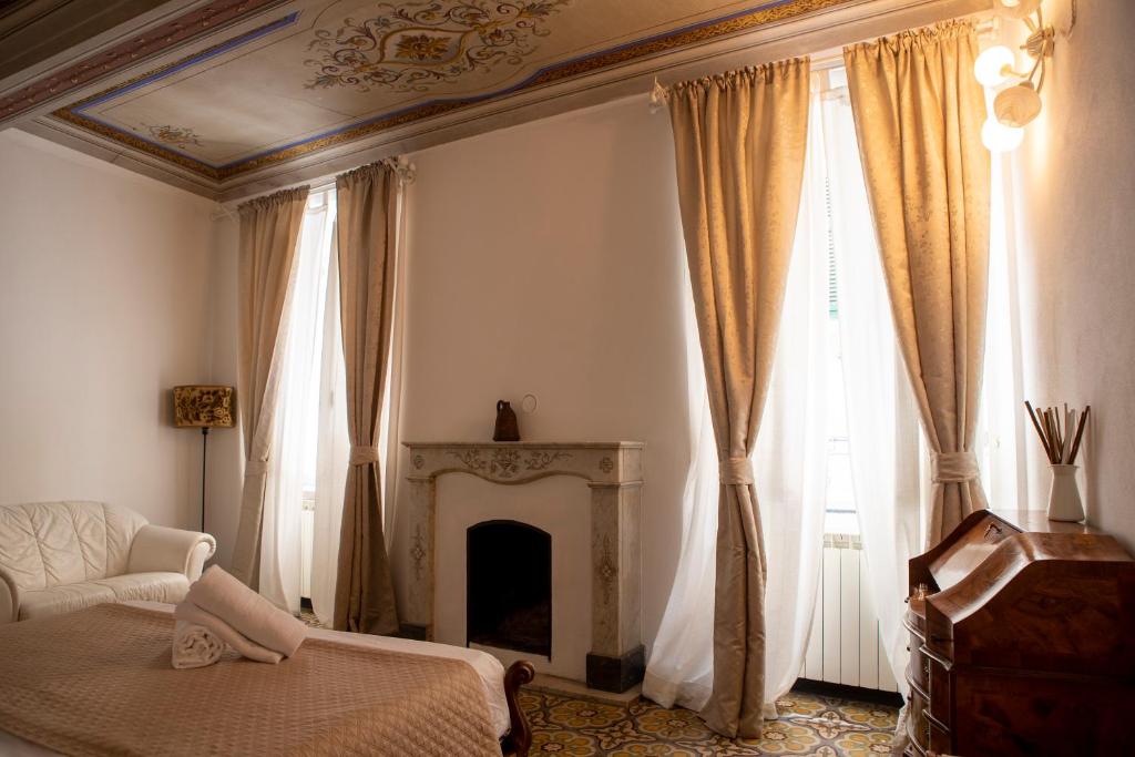 a living room with a fireplace and a bed and curtains at White Lerici in Lerici