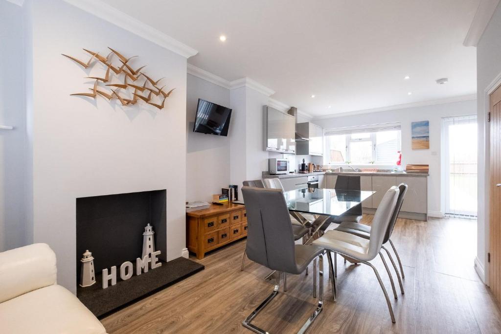 a living room with a dining table and a fireplace at Pigwig Cottage, Thorpeness in Thorpeness