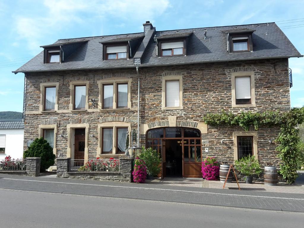 a brick building with flowers in front of it at Weingut Licht-Stadtfeld in Brauneberg