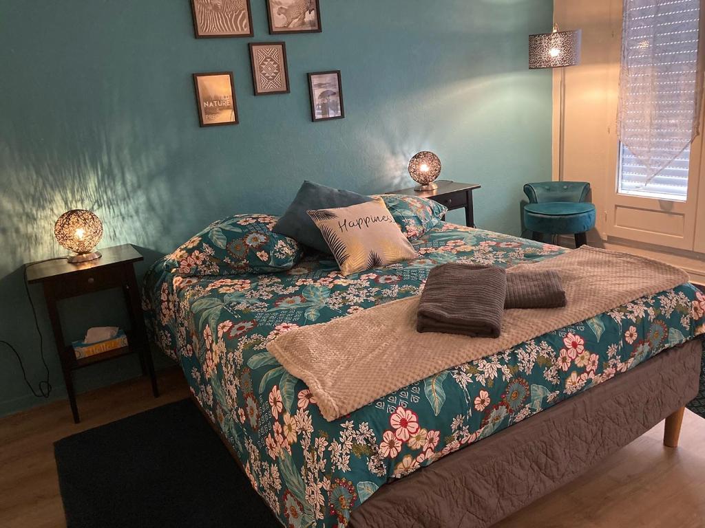 Chez Karine 1 في أرباجون: غرفة نوم عليها سرير وبطانية
